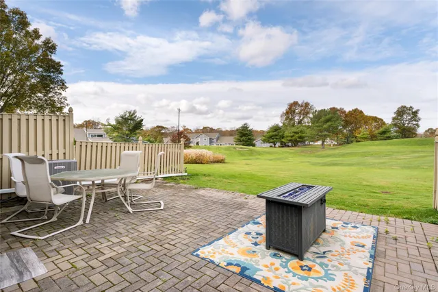 a view of a lake with table and chairs next to a yard