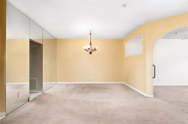 a view of a big room with chandelier fan and windows