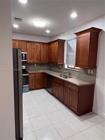 a kitchen with stainless steel appliances granite countertop a stove a sink and a refrigerator