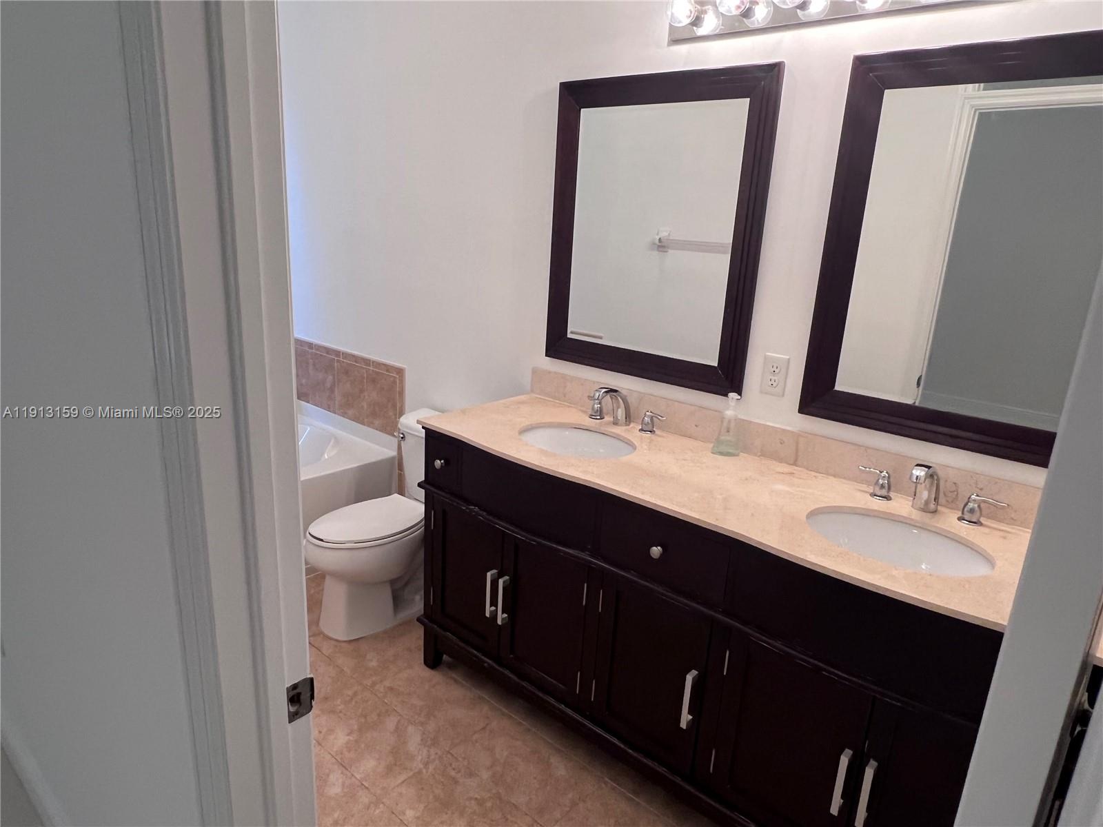 9801 Northwest 9th Street, Unit 9801 Miami, FL 33172 - Photo 6 of 7 a bathroom with a double vanity sink toilet and mirror