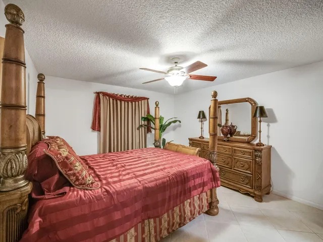 a bedroom with a bed and dresser with mirror