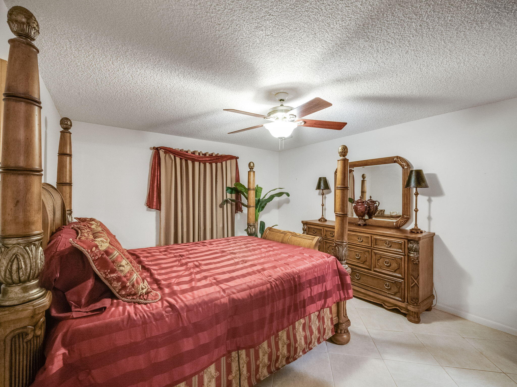 3525 South Ocean Boulevard, Unit 107 South Palm Beach, FL 33480 - Photo 15 of 21 a bedroom with a bed and dresser with mirror