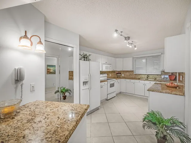 a kitchen with white cabinets and white appliances