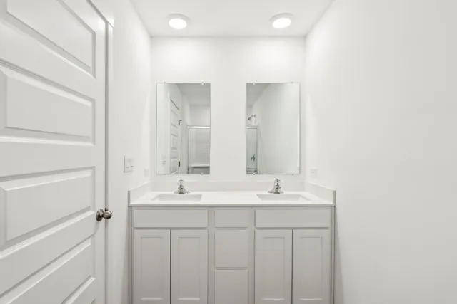 a bathroom with a double vanity sink and a mirror