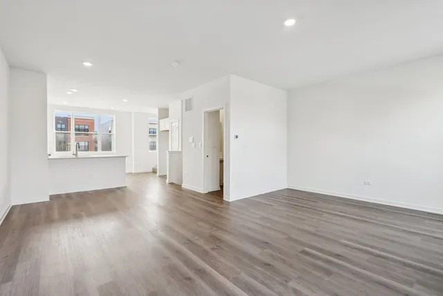 a view of empty room with wooden floor and window
