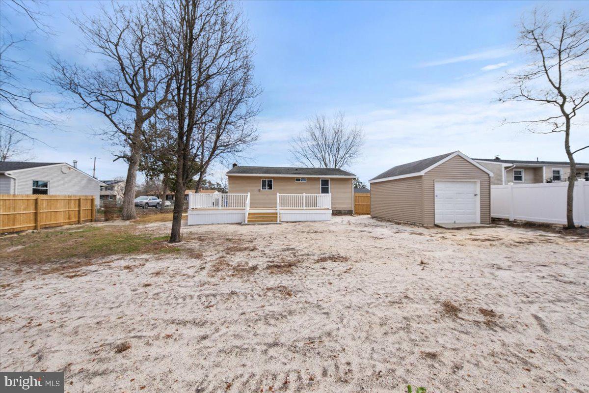 308 Apache Trail Browns Mills, NJ 08015 - Photo 31 of 34 a front view of a house with a dirt yard and a large tree