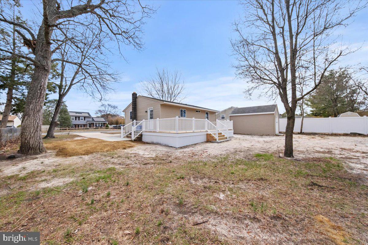 308 Apache Trail Browns Mills, NJ 08015 - Photo 33 of 34 a backyard of a house with large trees and wooden fence