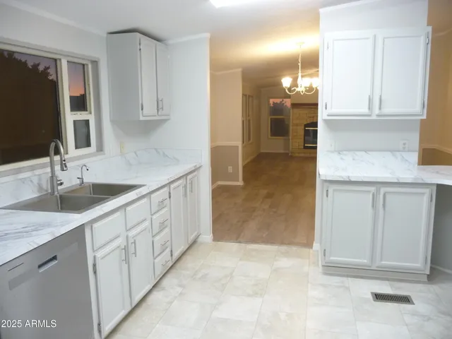 a kitchen with granite countertop white cabinets stainless steel appliances and sink