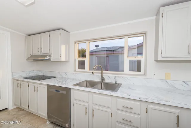 an empty room with wooden floor cabinet and windows