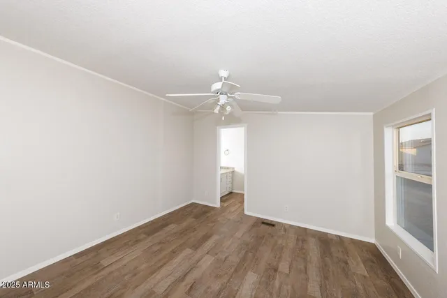a view of an empty room with closet and wooden floor