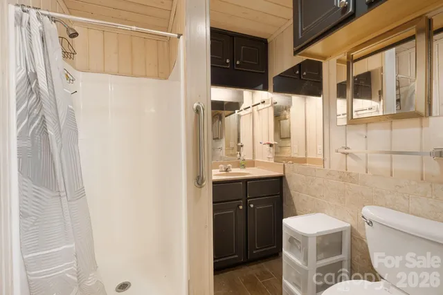 a bathroom with a sink a toilet and shower