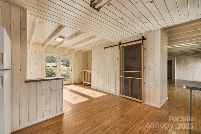 a view of a hallway with wooden floor and staircase