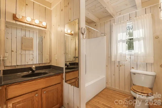 a bathroom with a sink a toilet a mirror and a shower