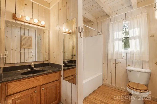 a bathroom with a sink a toilet a mirror and a shower