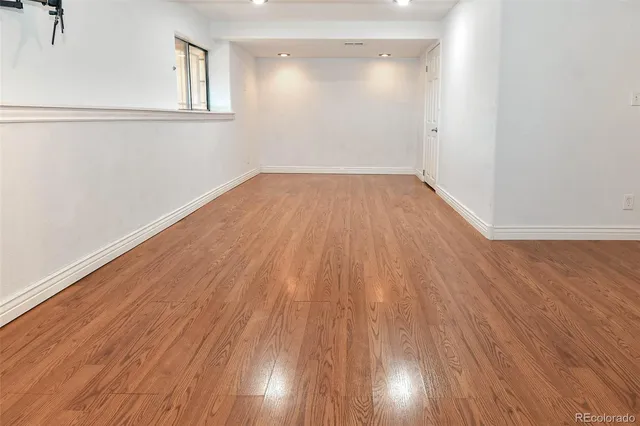 a view of an empty room with wooden floor