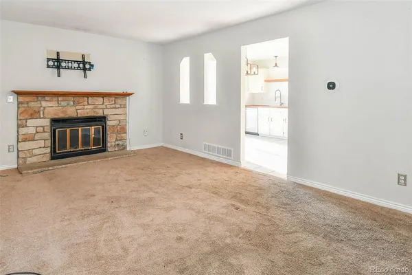 an empty room with windows and fireplace