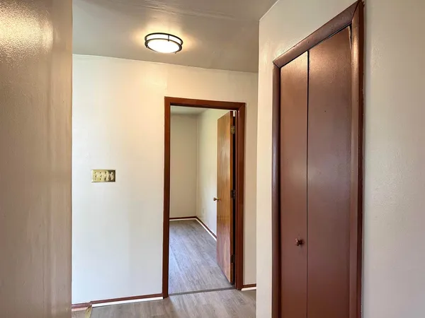 a view of a hallway with wooden floor