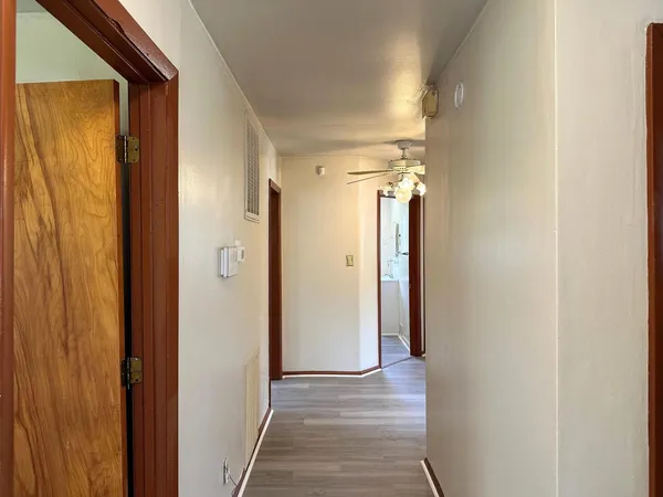 a view of a hallway with wooden floor and staircase