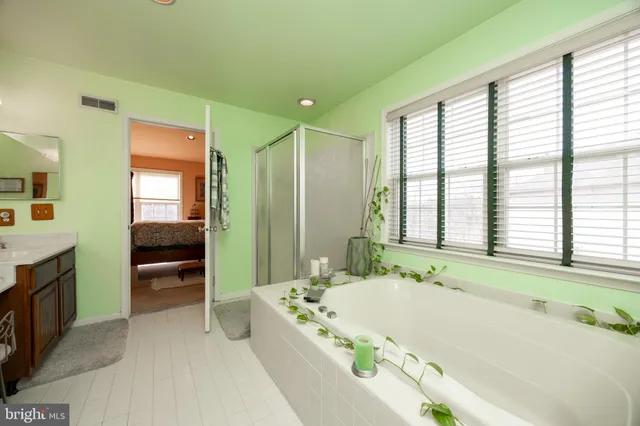 a spacious bathroom with a granite countertop tub sink and mirror