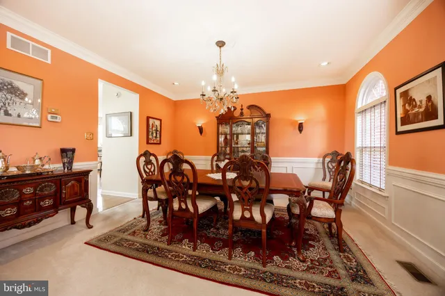 a dining room with furniture a rug and a chandelier