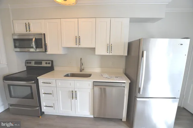 a kitchen with stainless steel appliances granite countertop white refrigerator stove a microwave and cabinets