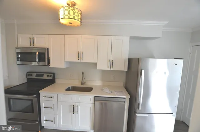 a white refrigerator freezer and a stove sitting inside of a kitchen