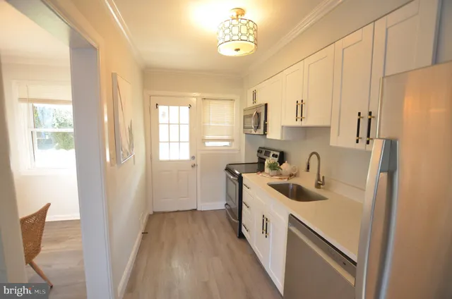 a view of a kitchen with a sink and dishwasher wooden floor