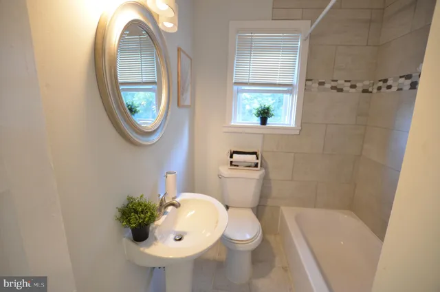 a bathroom with a sink toilet and a mirror