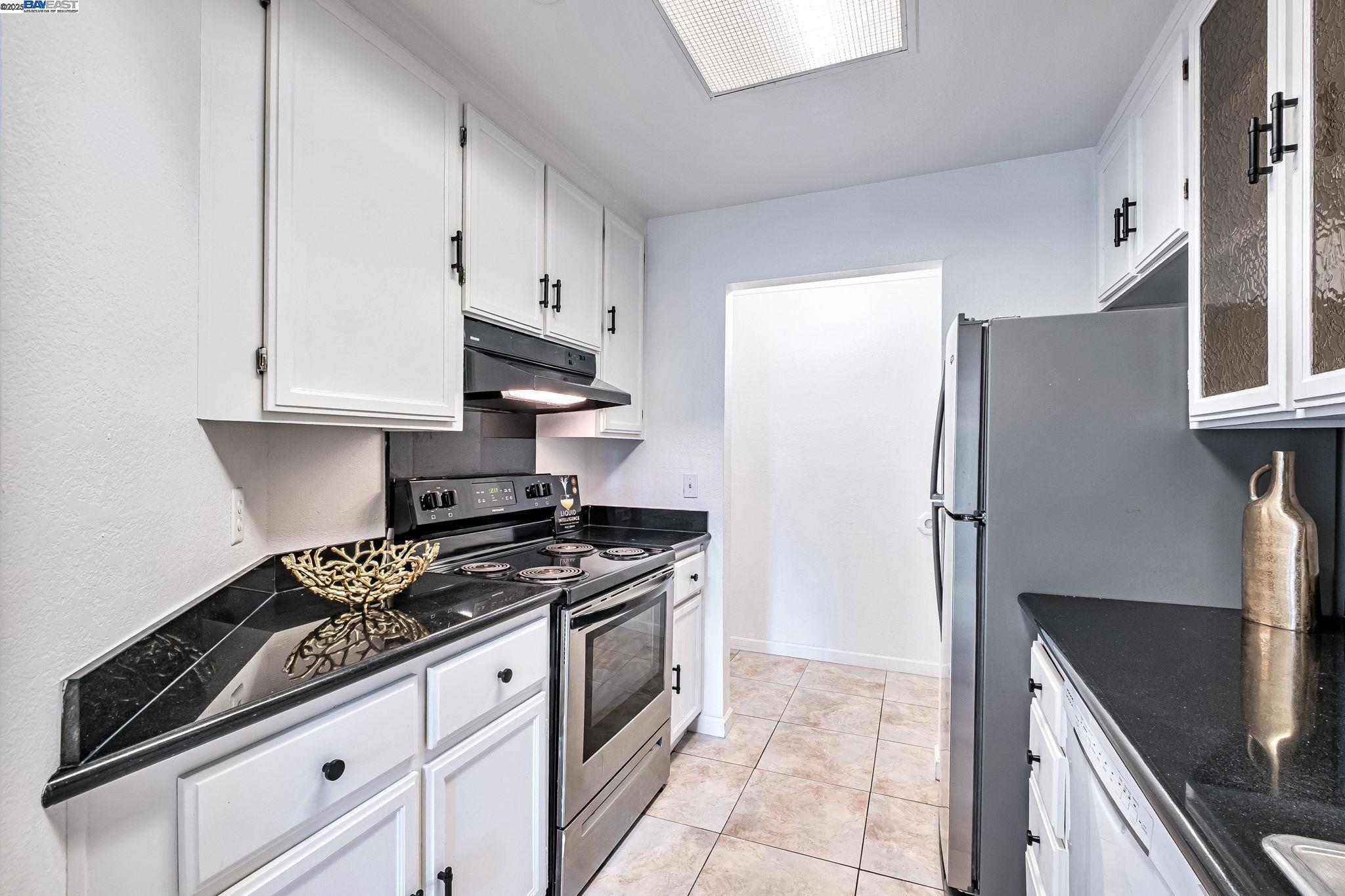 1960 Barrymore Common, Unit K Fremont, CA 94538 - Photo 10 of 31 a kitchen with stainless steel appliances a refrigerator a stove and white cabinets