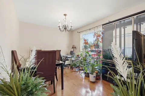 a view of a dining room with furniture a chandelier and wooden floor