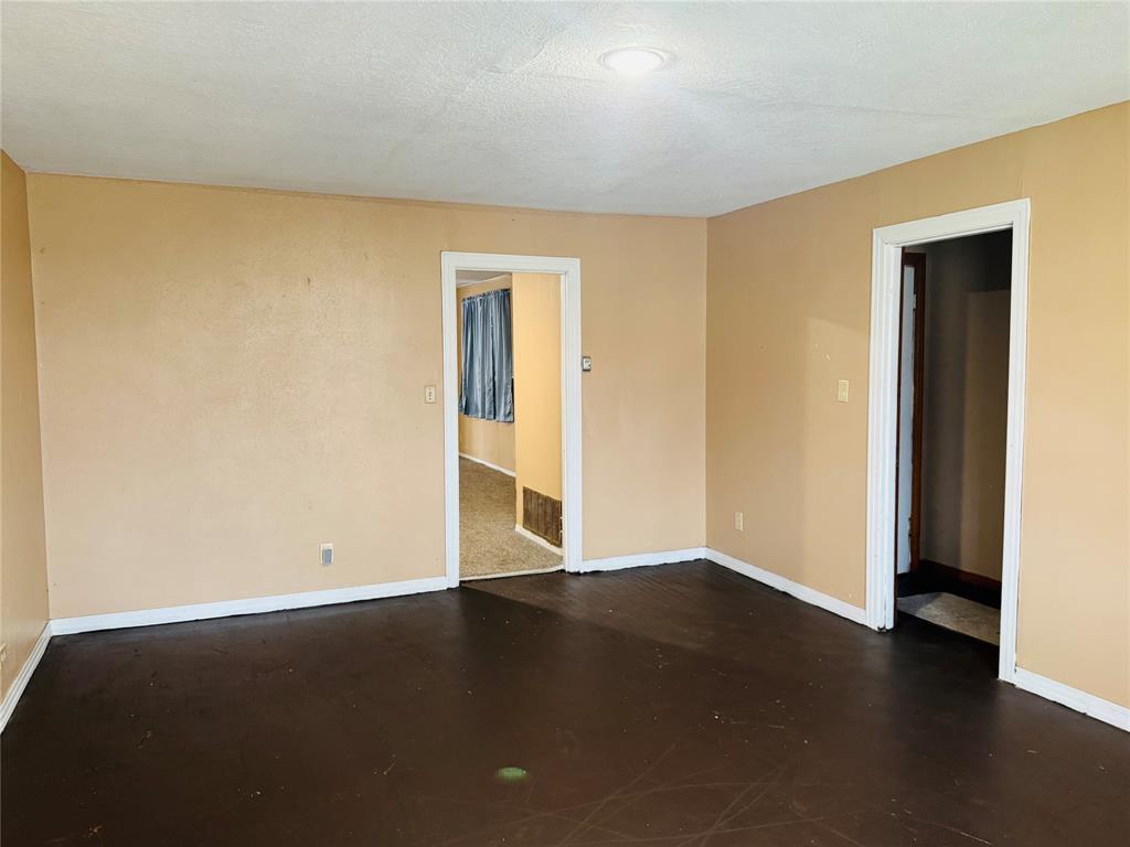 306 North Ave D Haskell, TX 79521 - Photo 4 of 7 a view of an empty room with wooden floor and a window