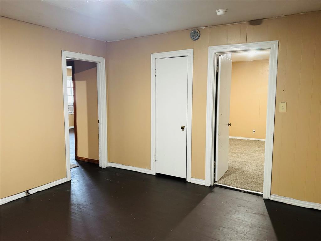306 North Ave D Haskell, TX 79521 - Photo 7 of 7 an empty room with wooden floor and a window