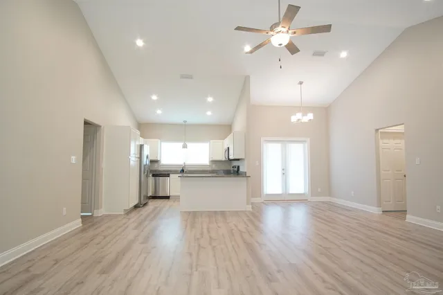 a large kitchen with a wooden floor and stainless steel appliances
