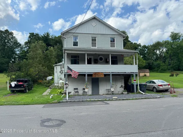 a front view of a house with a garden and plants