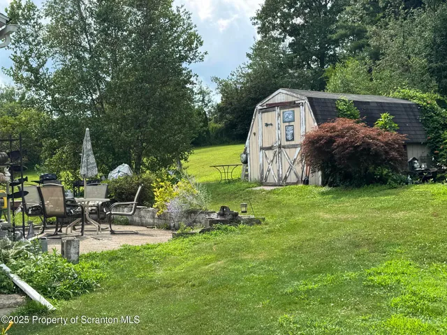 a view of a house with backyard and sitting area