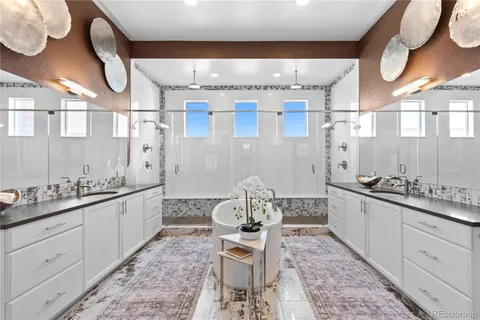 a large bathroom with a double vanity sink a toilet a mirror and shower