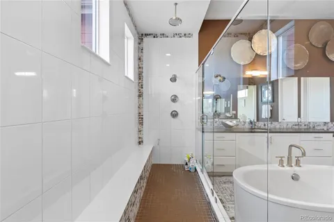 a bathroom with a bathtub a sink and a large mirror
