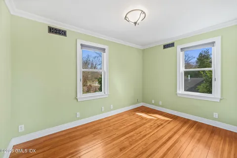a view of a room with wooden floor and windows