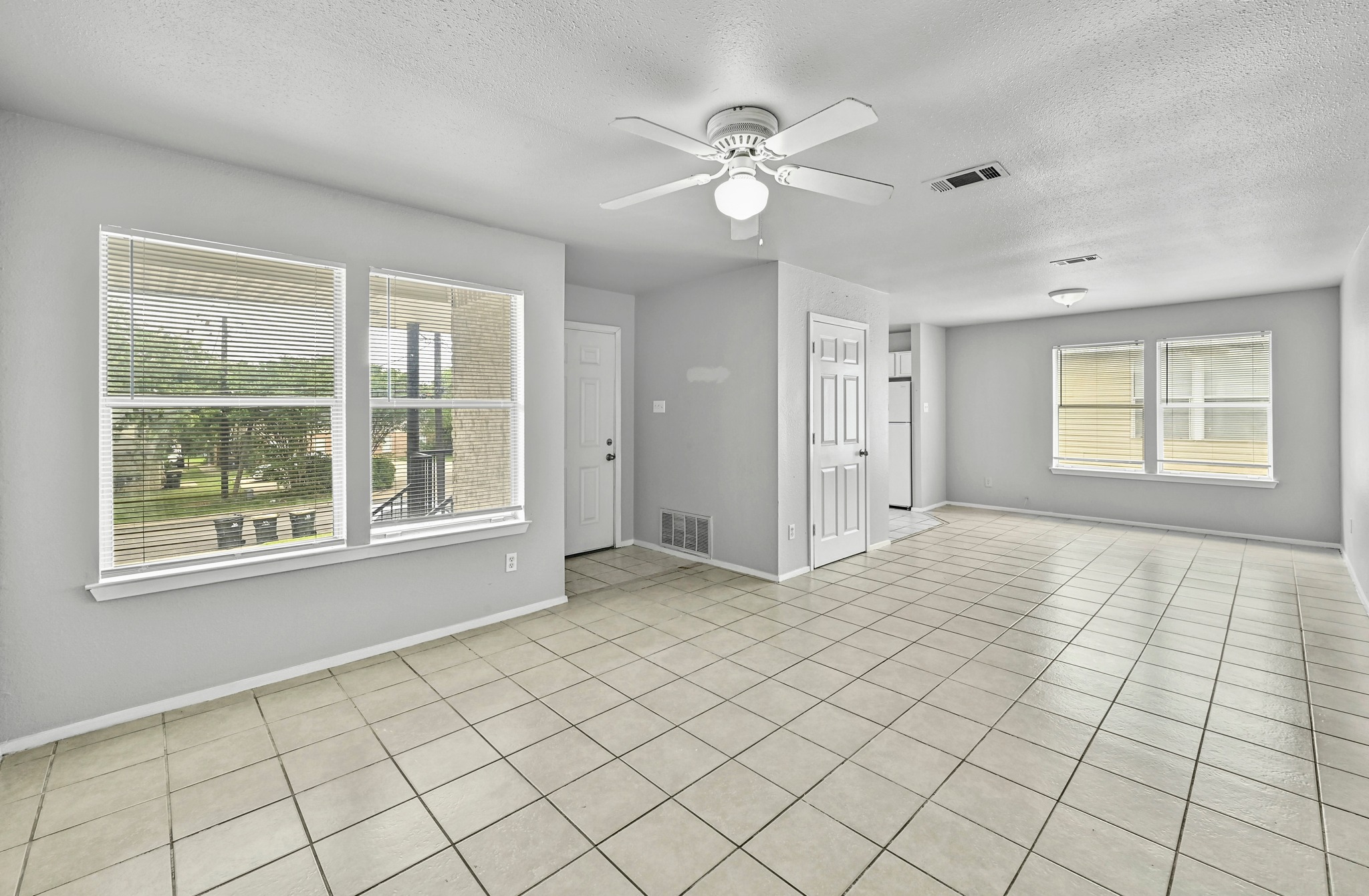2212 Katy Lane Georgetown, TX 78626 - Photo 6 of 27 Spacious living area featuring tiled flooring, multiple windows providing natural light, and a ceiling fan