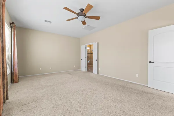 an empty room with closet and fan