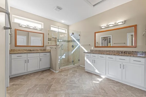 a spacious bathroom with a granite countertop sink and a mirror