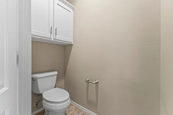a bathroom with a granite countertop toilet and a sink