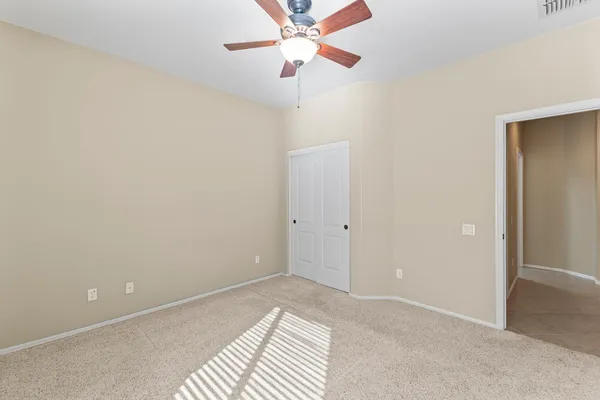 a view of a room with a ceiling fan and a fan
