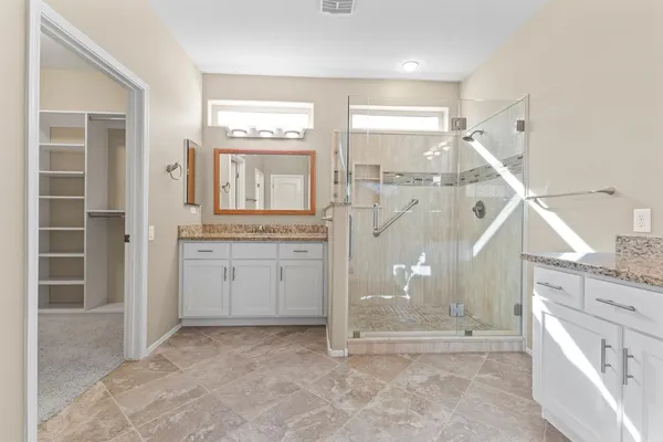 a spacious bathroom with a granite countertop sink and a mirror