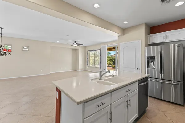 a spacious bedroom with a large bed and a chandelier