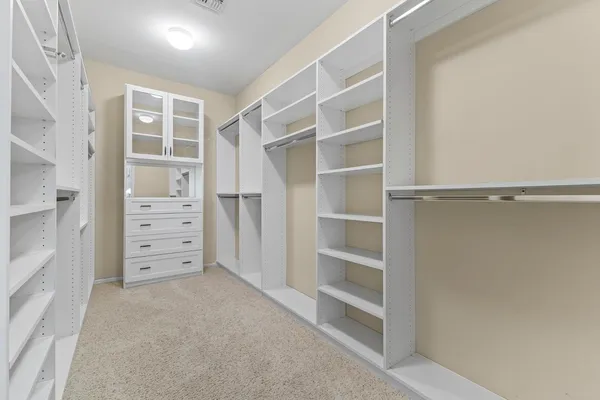 a view of walk in closet with empty racks