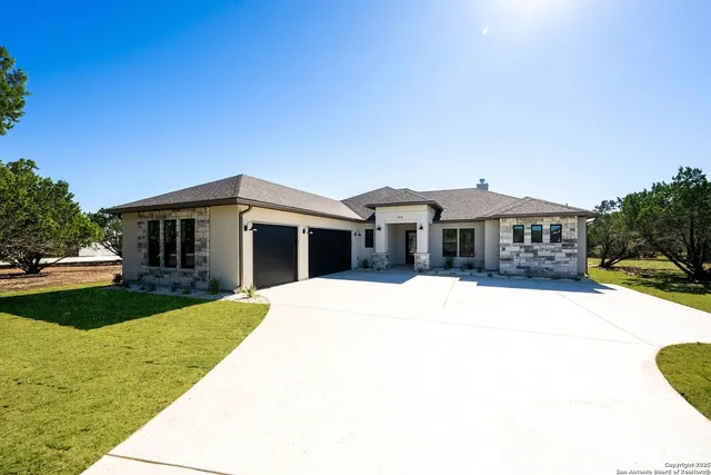 a front view of a house with yard and green space