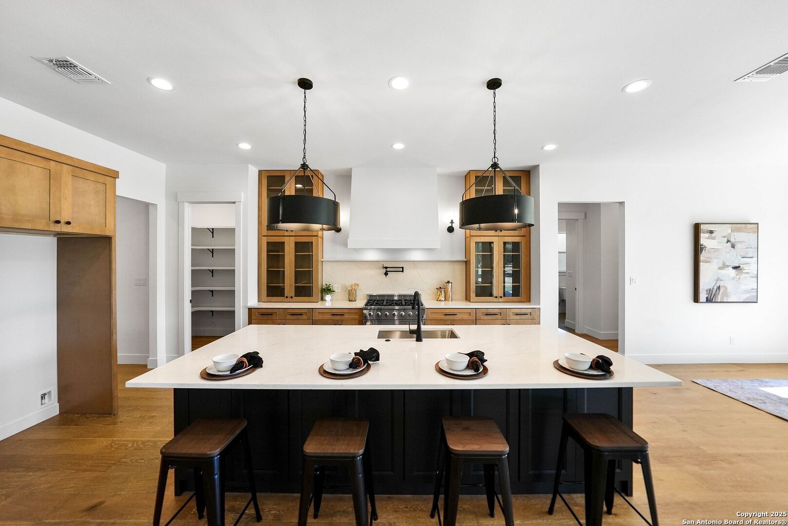414 Rio Azul Drive Pipe Creek, TX 78063 - Photo 7 of 51 a dining room with stainless steel appliances a table chairs and kitchen view