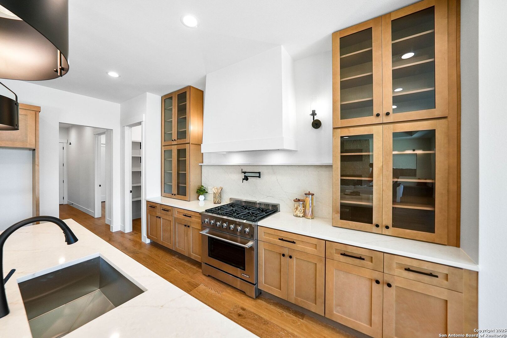 414 Rio Azul Drive Pipe Creek, TX 78063 - Photo 8 of 51 a kitchen with stainless steel appliances granite countertop a stove a sink and a refrigerator with wooden floors