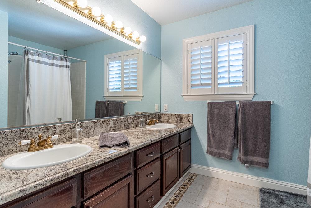 8955 Ridgeway Drive Gilroy, CA 95020 - Photo 33 of 64 a bathroom with a granite countertop sink and a mirror